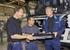 Volvo Truck Corporations President and CEO, Staffan Jufors (right), is helped on the production line by his new colleagues (l-r), Erland Lyckhage and Roslan Hasan